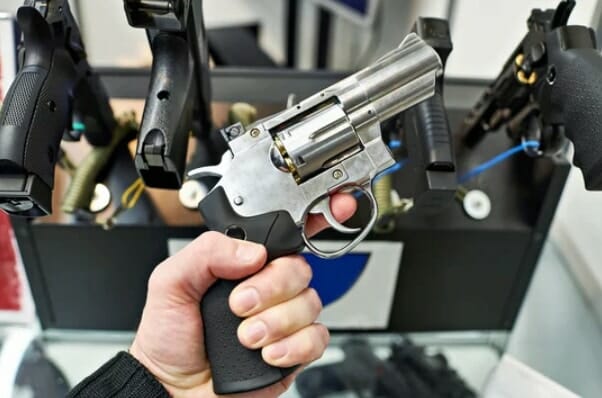 a person holding a handgun n a gun store