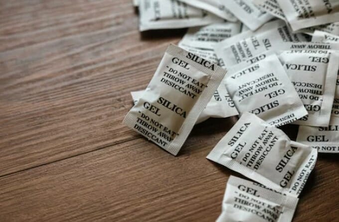 a stack of silica gel packs on the wooden surface