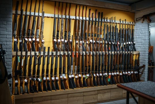 A lot of rifles displayed on a wall