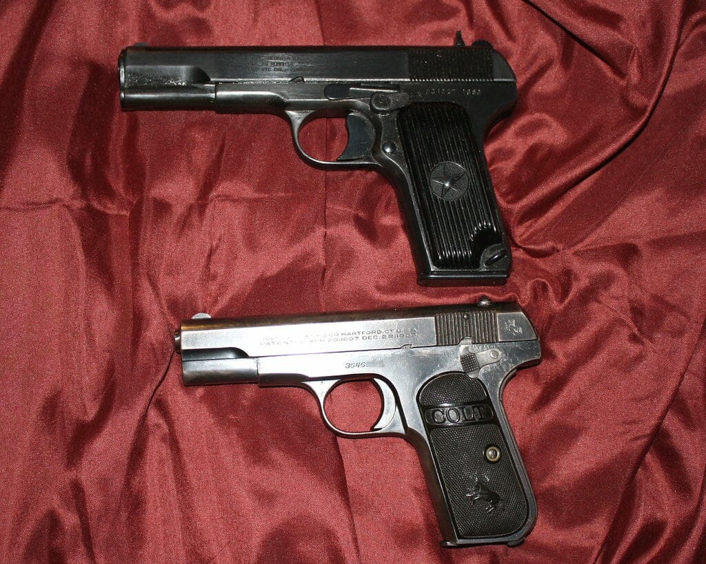 Two guns on a crimson sheet