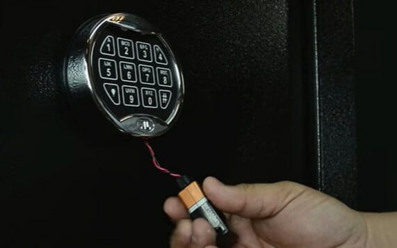 A person changing the battery on the safe lock