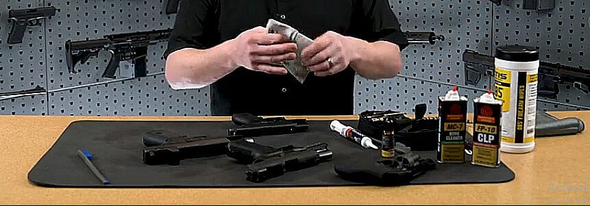 A person cleaning the pistols