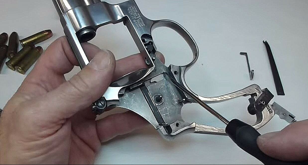 A person disassembling a revolver