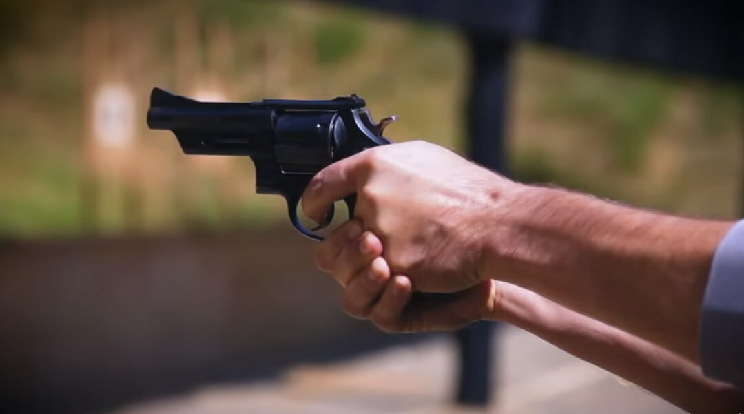 A person shooting a revolver